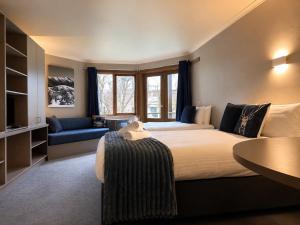 a large bedroom with a large bed and a couch at High Plains Lodge Rooms in Dinner Plain