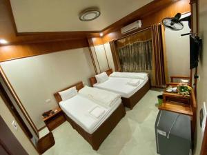 a small room with two beds and a television at Khách sạn Tam Sơn in Ha Giang