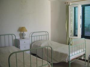 1 dormitorio con 2 camas y ventana en Casa Mansa en Porto Santo