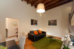 ローマにあるFL Apartments Charming Flat in the heart of Trastevereのリビングルーム(黒いソファ、緑の敷物付)
