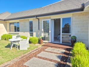 a house with a patio with a table and chairs at Monarch Park Studio in Cambridge