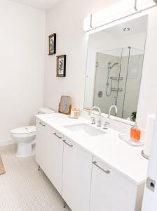 a white bathroom with a sink and a toilet at Sapphire Loft Midtown in Atlanta
