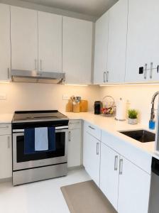 a kitchen with white cabinets and a stove top oven at Sapphire Loft Midtown in Atlanta +6 photos