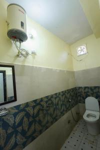 a bathroom with a toilet and a air conditioner on the wall at Green Valley Hotel - Srinagar in Srīnagar +26 photos
