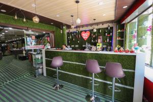 a bar with purple stools in a store at Green Valley Hotel - Srinagar in Srīnagar