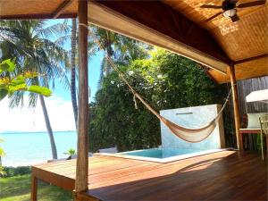 a hammock on the deck of a resort with the ocean at Nibbana Bungalows in Hinkong +26 photos