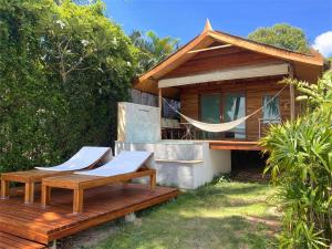 a house with two deck chairs and a hammock at Nibbana Bungalows in Hinkong