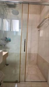 a shower with a glass door in a bathroom at Moses Home in Tjilandak