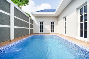 a swimming pool in front of a house at M Villa in Jetis