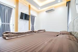 a bedroom with a bed and a tv on the wall at M Villa in Jetis