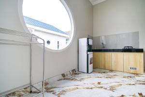 an empty kitchen with a window and a refrigerator at M Villa in Jetis