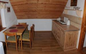 a kitchen with a wooden table and a wooden table and chairs at Apartmán Belko in Hrádek