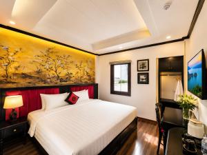 a bedroom with a bed and a painting on the wall at Hanoi Sena Hotel & Travel in Hanoi
