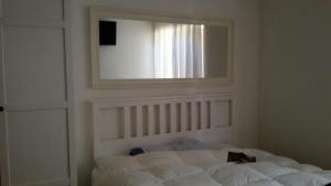 a bedroom with a white bed with a mirror at Ledro Charlotte House in Molina di Ledro
