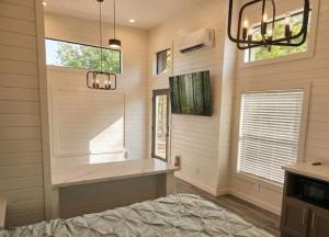un dormitorio con una cama, una ventana y una lámpara de araña en TH25 Red Rock Modern Tiny Home - 15 min to Sedona, en Cottonwood