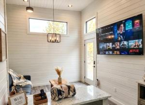 una sala de estar con un televisor y una mesa en TH25 Red Rock Modern Tiny Home - 15 min to Sedona, en Cottonwood 11 fotos más