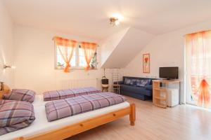 a bedroom with two beds and a blue couch at Lug ins Land in Spittal an der Drau