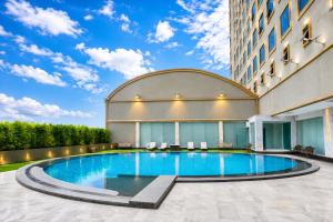 a swimming pool in front of a building at lee hotel lat phrao in Bangkok