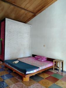 a room with a bed in the corner of a room at Susan Homestay in Batukaras
