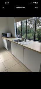 a kitchen with a sink and a window at Hinterland Ocean Vista Escape in Maroochy River +14 photos