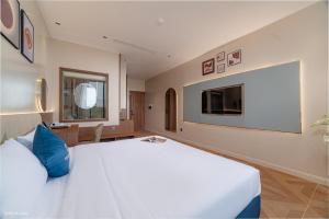a bedroom with a large white bed and a flat screen tv at Solaya Hotel in Tài Xá
