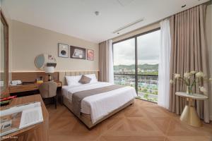 a hotel room with a bed and a desk and a window at Solaya Hotel in Tài Xá