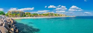 una playa con un grupo de edificios y el océano en Hotel Marina El Cid Spa & Beach Resort - All Inclusive, en Puerto Morelos