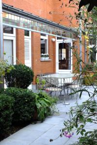 un patio con mesa y sillas frente a un edificio en B&B Sint Pieter, en Izegem