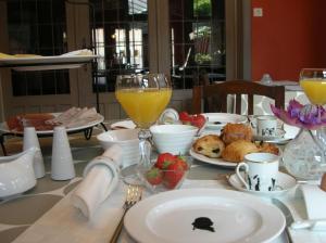 un tavolo con piatti di cibo e bicchieri di succo d'arancia di B&B Sint Pieter a Izegem
