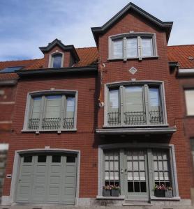 a red brick house with two garage doors and windows at B&B Sint Pieter in Izegem