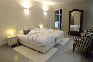 una camera da letto con un grande letto bianco e uno specchio di B&B Sint Pieter a Izegem