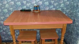 a wooden table with two stools and a pink top at Hotel Yuvileyny in Khrystynivka