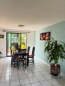 a dining room with a table and chairs and a potted plant at House check-in anytime after 3 pm in Jurica