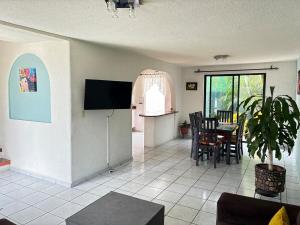 a living room with a television and a table and chairs at House check-in anytime after 3 pm in Jurica