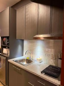 a kitchen with a sink and a counter top at D&J Cozy Family Studio Bacolod City in Bacolod