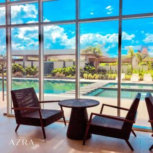 a room with a table and two chairs and a pool at D&J Cozy Family Studio Bacolod City in Bacolod