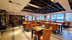 a restaurant with tables and chairs and a chalkboard at Platinum Grand in Dhaka