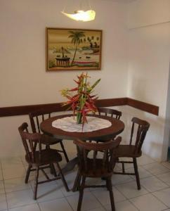 a dining room table and chairs with a plant on it at Apartamento Alice Tenório in Recife