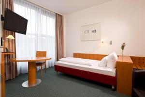 Postel nebo postele na pokoji v ubytování Hotel am Borsigturm
