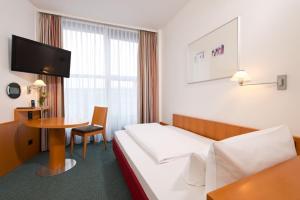 a hotel room with a bed and a television at Hotel am Borsigturm in Berlin