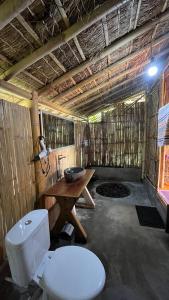 a bathroom with a toilet and a wooden table at Girang Rinjani Bungalows in Tetebatu