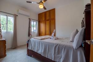 a bedroom with a bed and a ceiling fan at Cozy home in puerto plata in San Felipe de Puerto Plata +26 photos