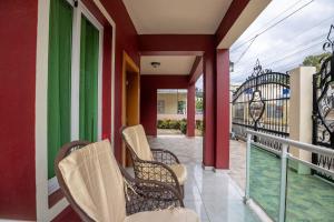 a balcony with chairs and a fence at Cozy home in puerto plata in San Felipe de Puerto Plata