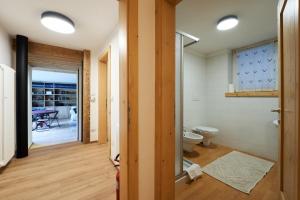 a bathroom with a toilet and a glass door at Lioda Pera Paradise in Pieve di Cadore +45 photos