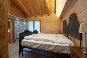 a bedroom with two beds in a wooden room at Lioda Pera Paradise in Pieve di Cadore