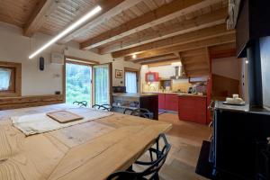 a kitchen and dining room with a wooden table at Lioda Pera Paradise in Pieve di Cadore