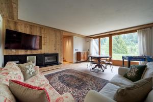 a living room with a couch and a tv at Lioda Pera Paradise in Pieve di Cadore