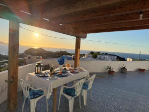 a table and chairs on a patio with the sunset at Ponzamania Terrazza sul tramonto in Ponza