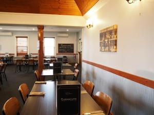 a dining room with wooden tables and chairs at Queenscliffe Hotel in Kingscote