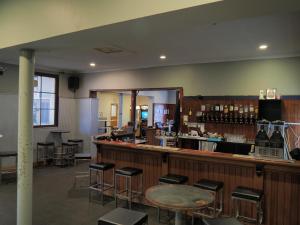 a restaurant with a bar with stools at Queenscliffe Hotel in Kingscote